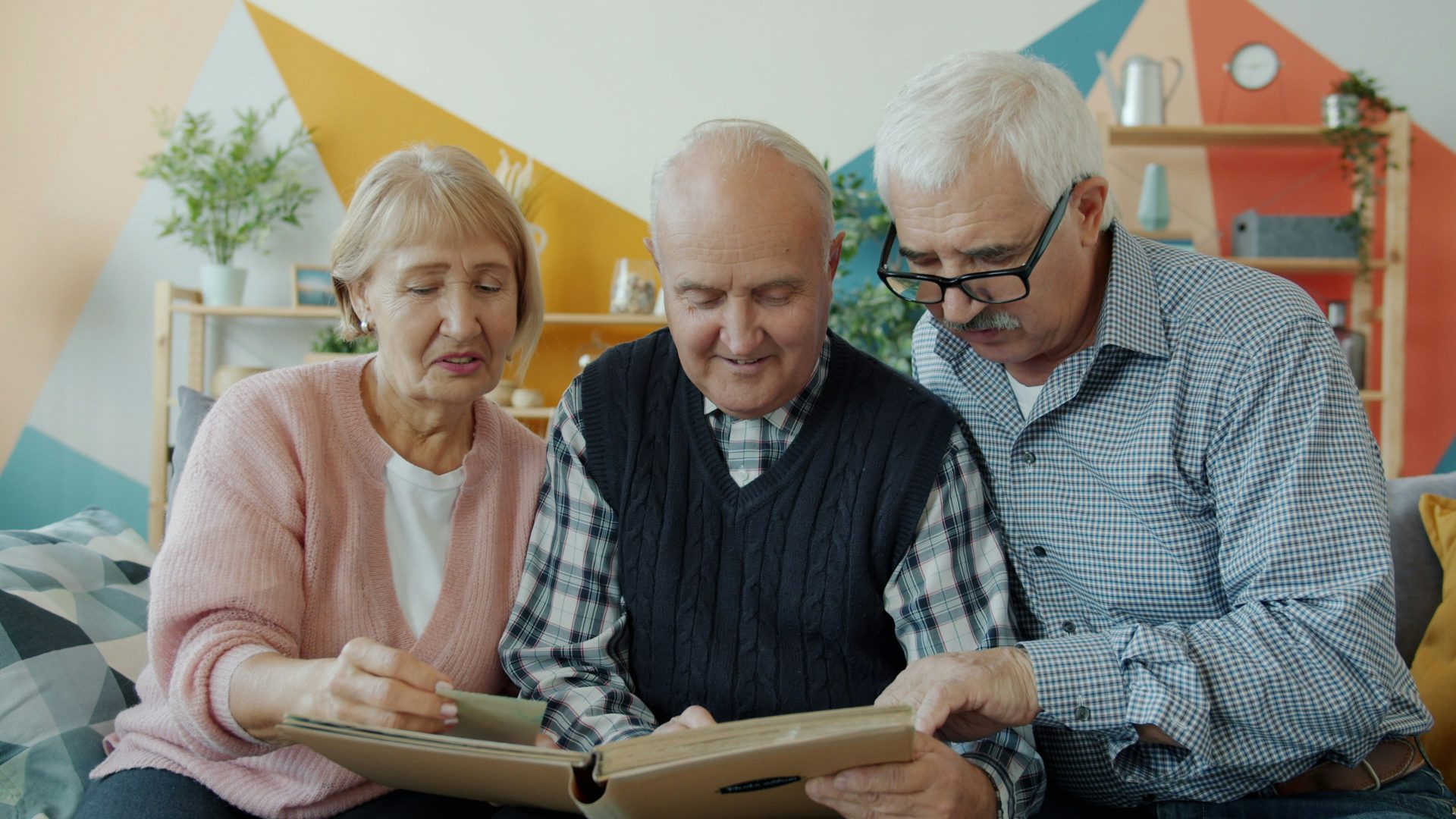 Three seniors looking at a photo album together